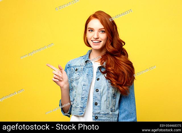 Lifestyle Concept: Happy excited cuacaisan tourist girl pointing finger on copy space isolated on golden yellow background