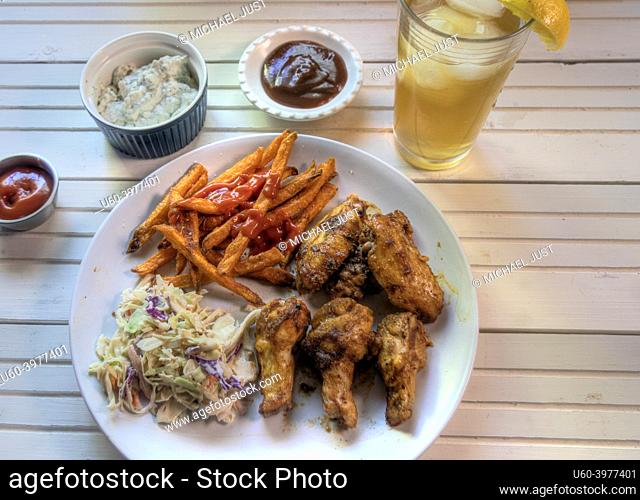 Top view of chicken wings dinner on natural white wood surface