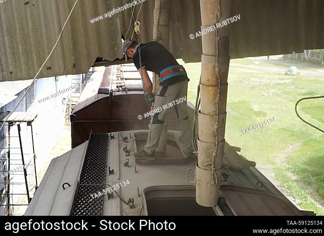 RUSSIA, ZAPOROZHYE REGION - MAY 16, 2023: Railway cars fill up with wheat at a grain storage facility in the village of Akimovka, Melitopol District