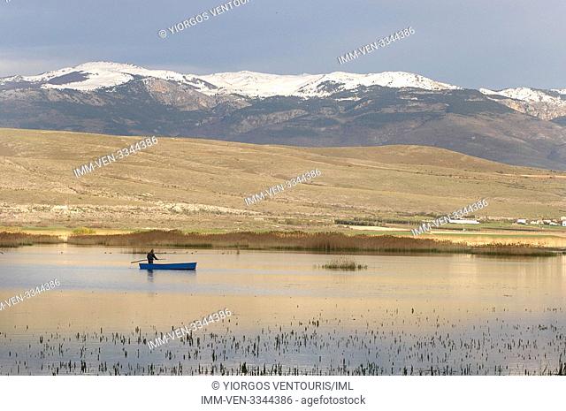 Fisherman in Lake Vegoritida that sits between the prefectures of Pella and Florina. Kaimaktsalan mountain visible in the background