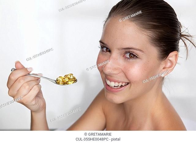 Woman eating spoonful of supplements