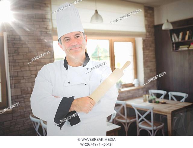 Male chef holding rolling pin in restaurant