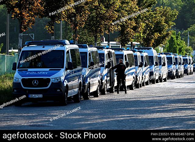 31 May 2023, Saxony, Dresden: Police cars stand in front of the Dresden Higher Regional Court (OLG) before the start of the sentencing of Lina E