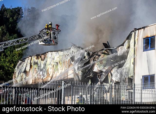 04 June 2022, Baden-Wuerttemberg, Fichtenberg: Firefighters extinguish the fire in a plastics plant. The property damage in the warehouse of the company in the...