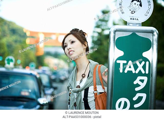 Young female waiting at taxi stand