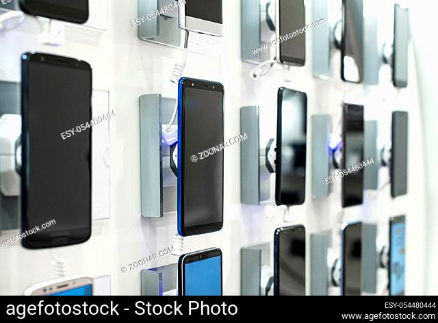 Smartphones on shelf in the store. Concept for communications and technology. Buying mobile phone in technology shop