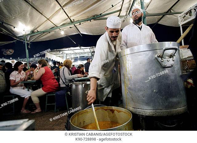 Two cooks cooking traditional corn tomate soup in a foodstall at Jemaa El Fna Square in Marrakech, Morroco, Maghreb, North Africa