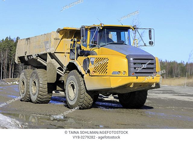 Lieto, Finland - March 22, 2019: Volvo A35E articulated dumper driving at speed along dirt road by a construction site on a sunny day of spring