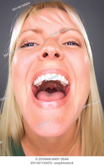 Laughing Blond Woman with Funny Face against a Grey Background