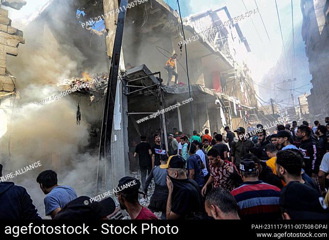 17 November 2023, Palestinian Territories, Rafah: Palestinians attempt to extinguish a fire after an Israeli air strike on a house in the Shaboura refugee camp