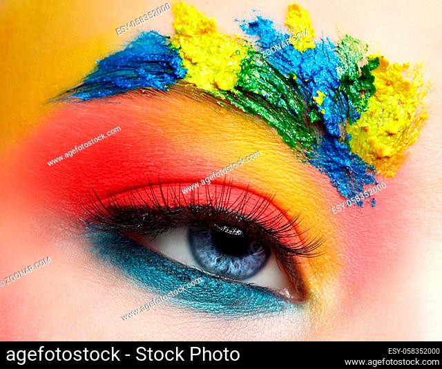 Close-up macro shot of teenager girl eye with unusual art make-up. Female face painting on brows and around eye