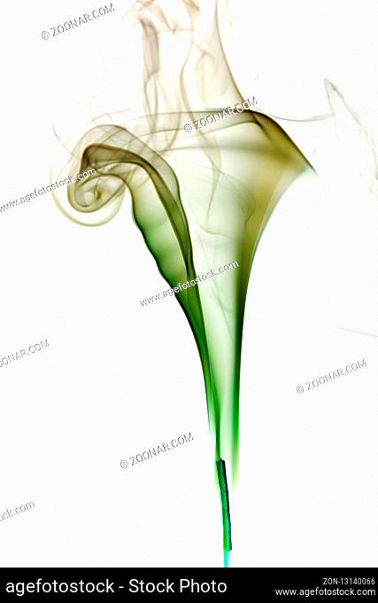 Colorful green smoke of incence stick isolated at white background