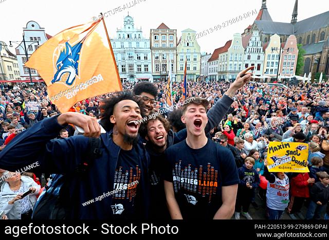 13 May 2022, Mecklenburg-Western Pomerania, Rostock: Fans and players of the Rostock Seawolves stand on the Neuer Markt and celebrate the promotion of the men's...