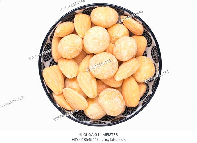 Nuts background. Close-up of roasted and salted macadamias and almonds nuts in ceramic bowl isolated on a white background