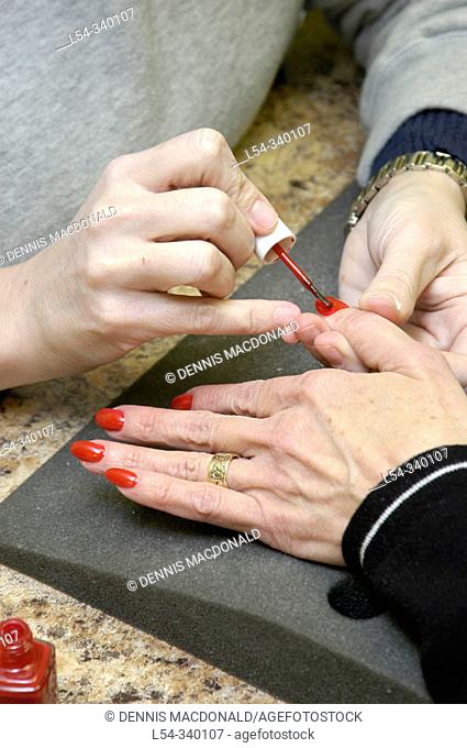 Woman has fingernails manicured by a professional