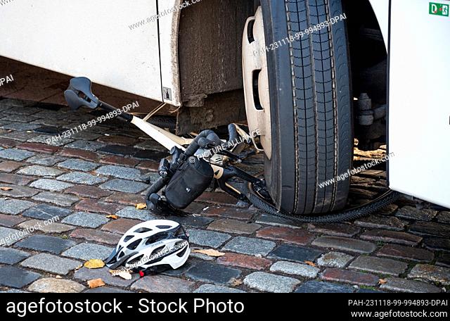 18 November 2023, Hamburg: A bicycle lies under the tire of a coach after an accident. When turning right, the bus overlooked a cyclist and seriously injured...