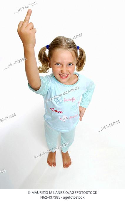 Angry little girl view from above makes a rude gesture showing her middle finger raising arm