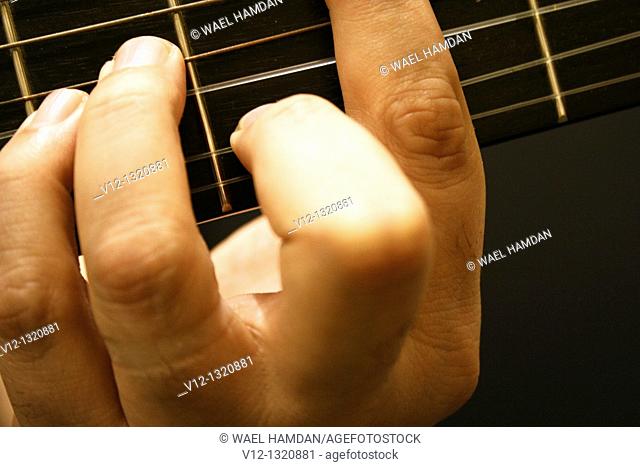 A close up view of musician's hand on guitar