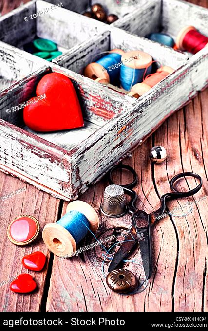 Wooden sewing box with threads, buttons and symbolic heart