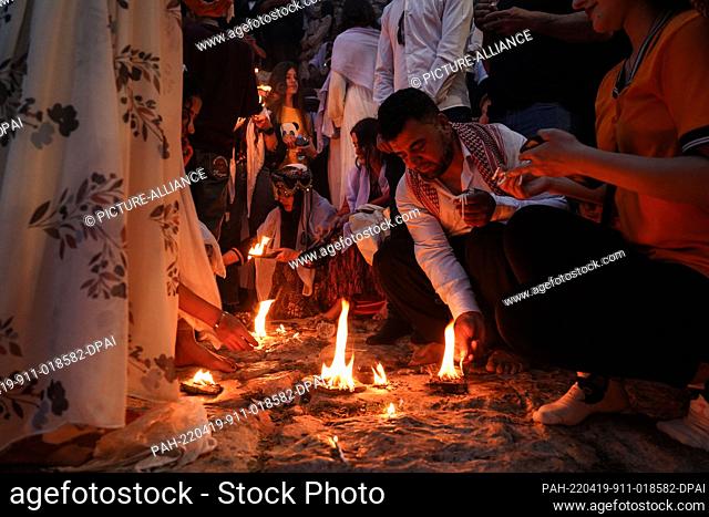 19 April 2022, Iraq, Dohuk: Iraqi Yazidis light candles and torches at the Lalish mountain valley and temple, the holiest shrine of the Yazidis