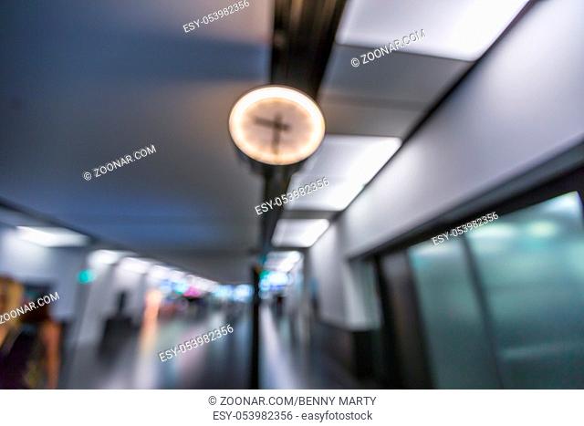 Closeup of clock in the corridors of an airport with blur effect. Abstract airport background