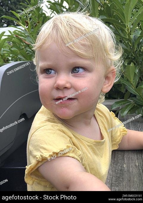 Blond little girl, two years old, looking aside in Scania, Sweden, Scandinavia