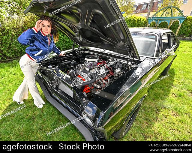 PRODUCTION - 26 April 2023, Brandenburg, Schwedt: Leokadia Hateville, airbrush and graffiti artist, stands in front of her American '69 Chevrolet Nova with a...
