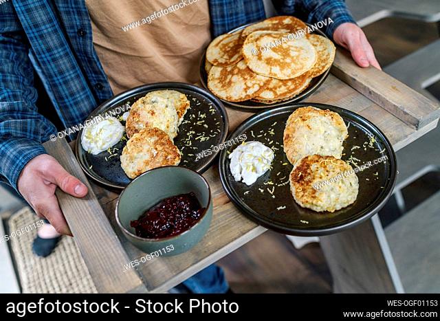 Teenage boy holding breakfast tray on weekend