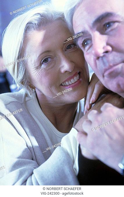 portrait, close up, tender couple mid of 50, blond woman wearing a natural white shirt and white haired man wearing a black shirt  - GERMANY, 01/02/2005