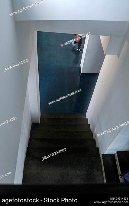Architecture, down a staircase into a hallway, blurred person passing by