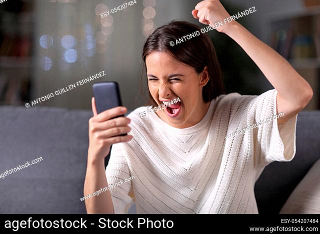 Excited girl finding amazing content on phone in the night