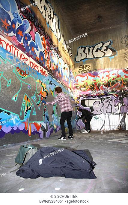 two young graffiti sprayers at work, United Kingdom, London