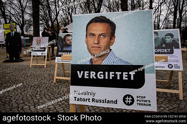10 April 2021, Berlin: Photos with Russian opposition members stand not far from the Brandenburg Gate on the street of June 17