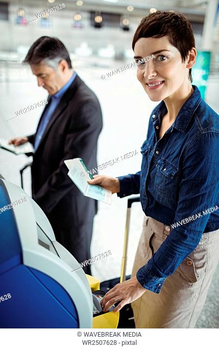 Businesswoman using self service check-in machine