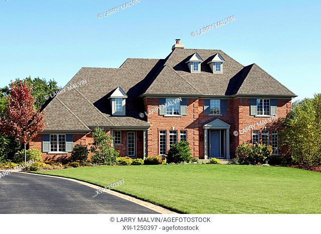 Large brick home with arched entry and blue door
