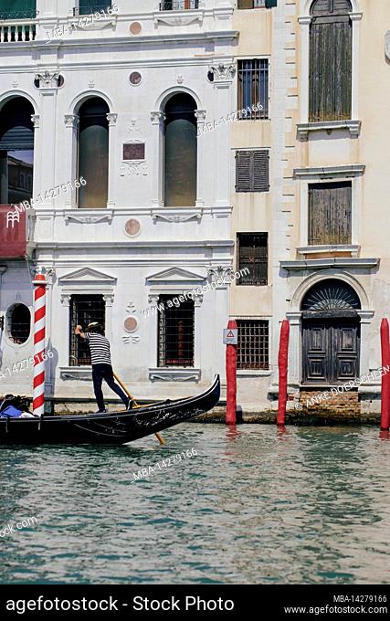Venetian gondola in front of a renovated building on the Grand Canal in Venice, Italy