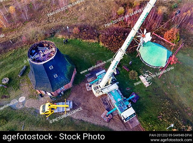 02 December 2020, Mecklenburg-Western Pomerania, Stove: A crane is used to remove the mill cap of the windmill, which weighs around 17 tons, for renovation work