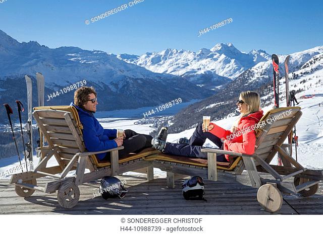 Couple in deck chairs in mountain restaurant Trutz, Engadine