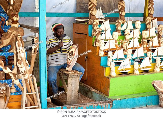 Black native Bahamian carves wooden gifts and souvenirs at the Straw Market in Nassau, Bahamas