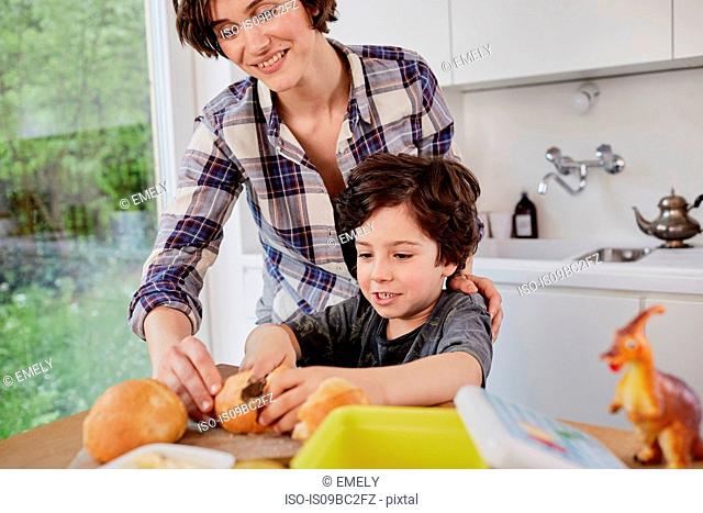 Mother and son preparing food in kitchen