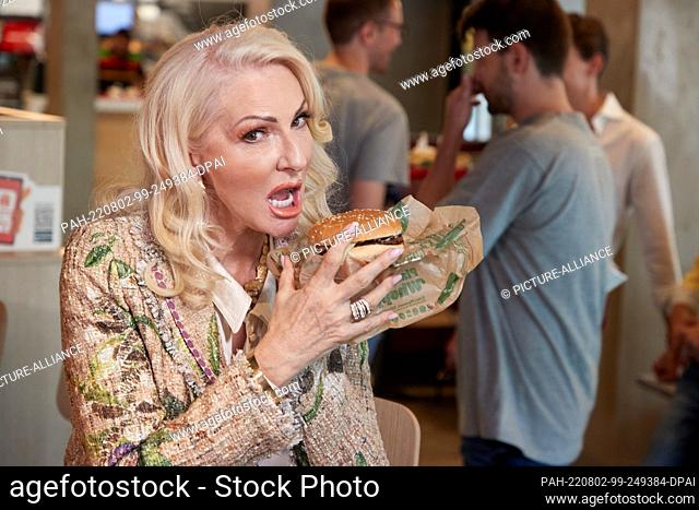 02 August 2022, Hamburg: Désirée Nick, actress, presents a Plant-based Whopper at a press event of the fast food chain Burger King at the branch on Mundsburger...