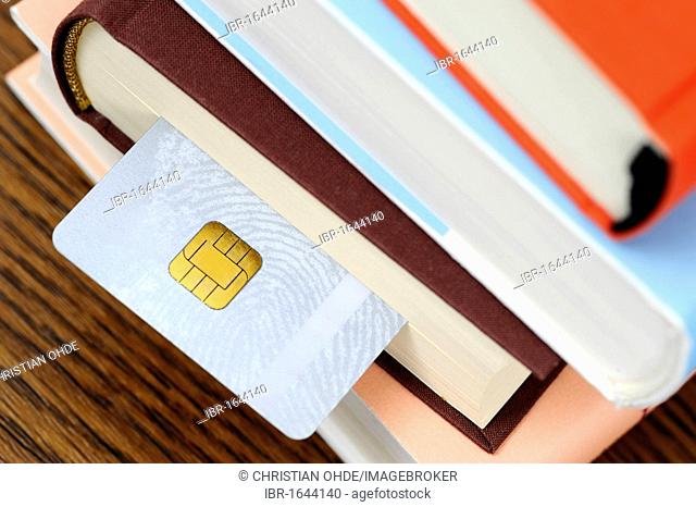 Smart card in a stack of books, symbolic image for an educational smart card