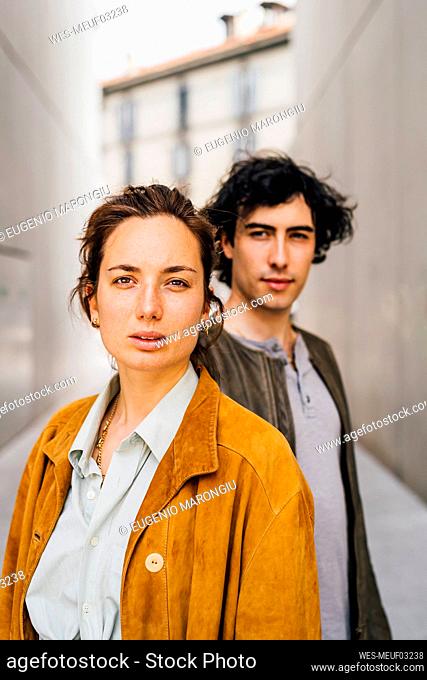 Girlfriend staring with boyfriend standing in background