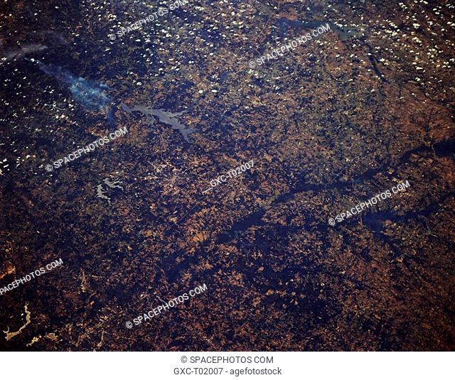 Featured beneath cumulus clouds are Cedar Creek Lake upper right edge, a tributary of the Trinity River basin, in this forested region of northeast Texas and...