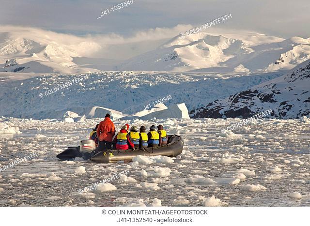 Tourists cruise in Zodiac inflatable boat in thick brash ice, Cierva Cove, Antarctic Peninsula