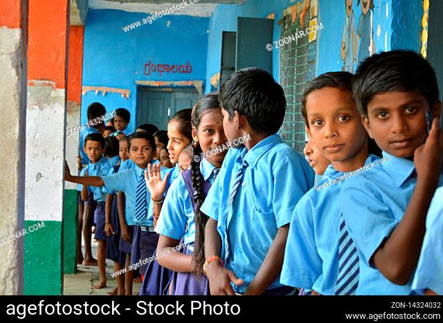 Mernal, Karnataka, India 25 July, 2019 : Government school Children having fun while standing in que