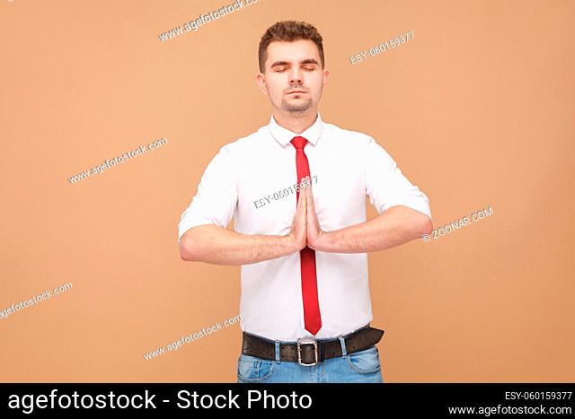 Relaxed businessman doing yoga . Business people concept, good and bad emotion and feelings. Studio shot, isolated on light brown background
