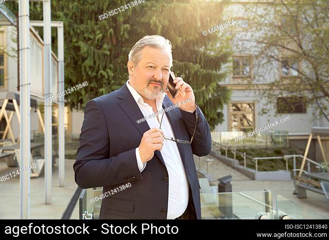 Austria, Vienna, Businessman talking on smart phone in city