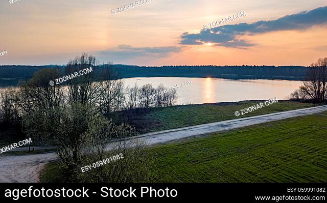 Aerial view shot by a drone of a beautiful dramatic and colorful sunset at coast of the lake. Nature landscape. Nature in Europe