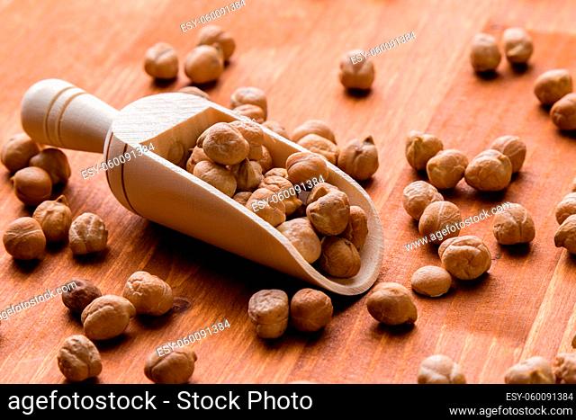 dry brown chickpeas with wooden scoop on table